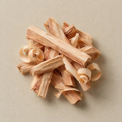 Split hinoki wood sticks and shavings on pale stone