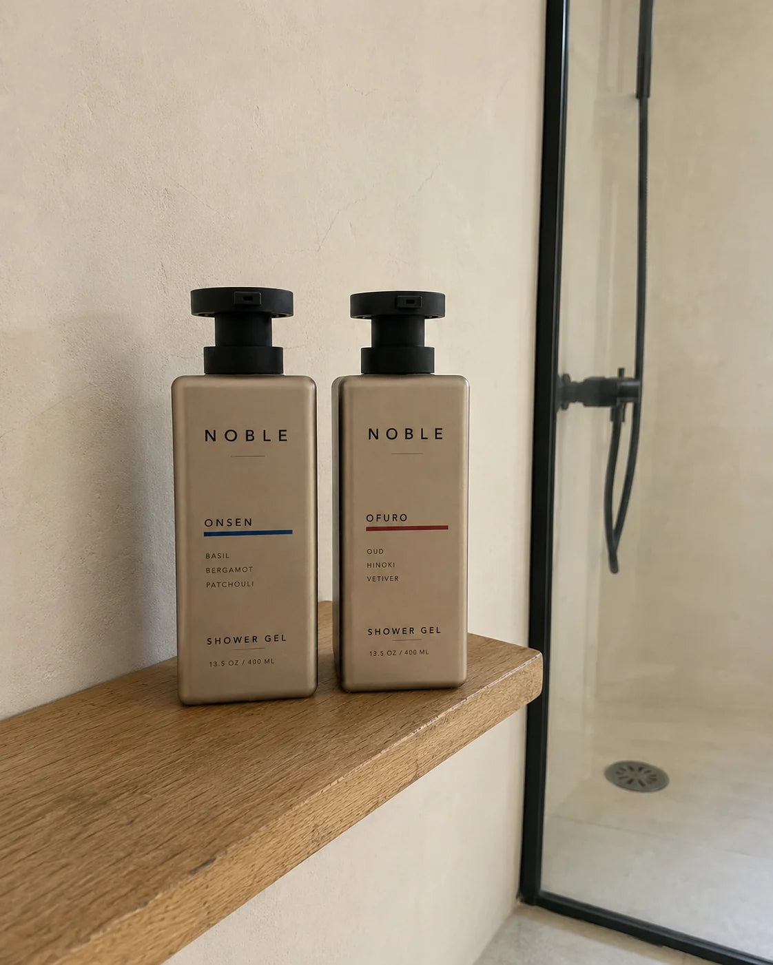 ONSEN and OFURO 13.5 oz metal bottles on a light oak shelf beside a glass shower